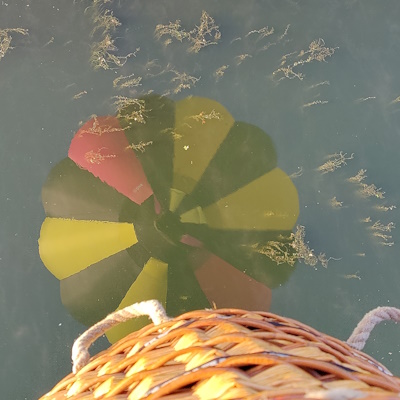 Weerspiegeling luchtballon boven water